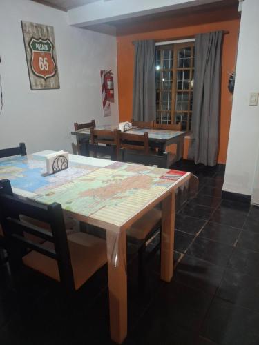 a dining room with a table and chairs and a table and benches at Posada Ruta 65 in General Fernández Oro