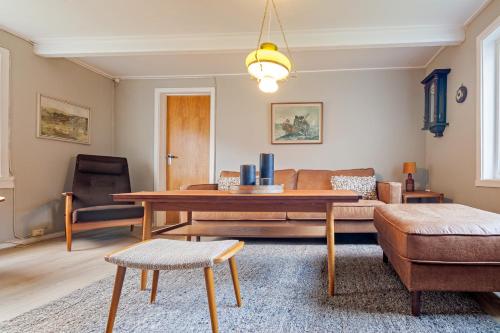 a living room with a table and a couch at Heimly, cosy house in a fjord in Bjørnsand