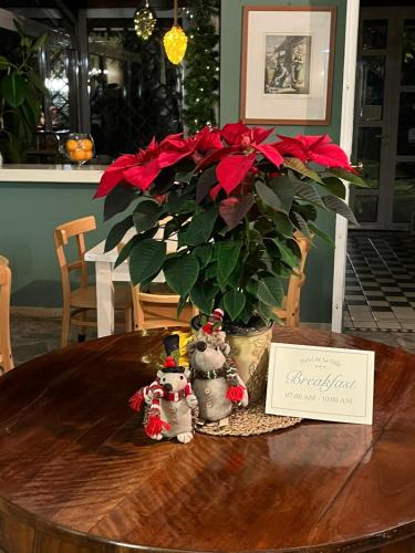 een tafel met een potplant met rode bloemen bij Hotel De La Ville in Bereguardo