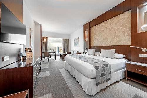 a hotel room with a large bed and a desk at Riu Plaza Panamá in Panama City