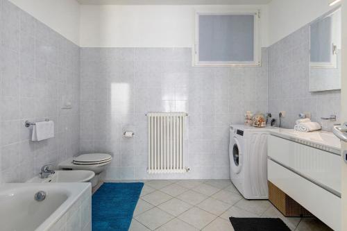 a bathroom with a toilet a sink and a washing machine at Casa Martina in San Fermo della Battaglia