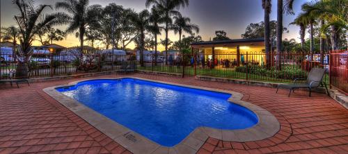 een zwembad in het midden van een bakstenen tuin bij Central Caravan Park in Perth