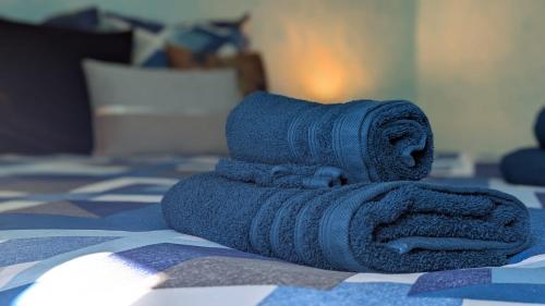 Una pila de toallas encima de una cama. en Gîte Le Grand Albizia, en Cellettes