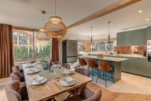 une cuisine avec une table et des chaises et une cuisine avec un comptoir dans l'établissement Chalet Diard, Detached Chalet, Alpes Travel, Sleeps 6 to 8, à Chamonix-Mont-Blanc