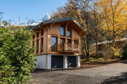 une maison en bois avec un balcon sur une allée dans l'établissement Chalet Diard, Detached Chalet, Alpes Travel, Sleeps 6 to 8, à Chamonix-Mont-Blanc