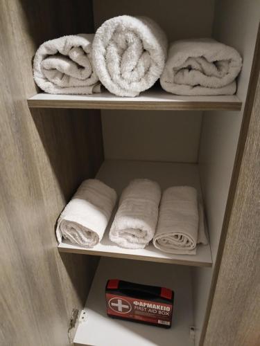 a closet with white towels and a box of aiazepoxide at Lux Rooms Pasha's Gardens Ιpirou 4 Agios Pavlos in Thessaloniki