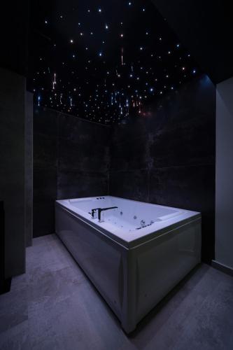 a white bath tub in a room with a star ceiling at Rei 2 in Belgrade