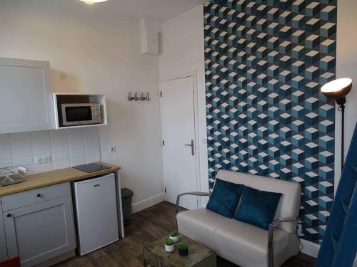 een kleine keuken met een stoel en een magnetron bij Marc1 in Saint-Valéry-en-Caux