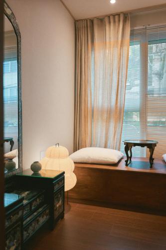 a bedroom with a bed and a window with a mirror at Seoul Station ㅣThe interior of a hanok with a terrace in Seoul