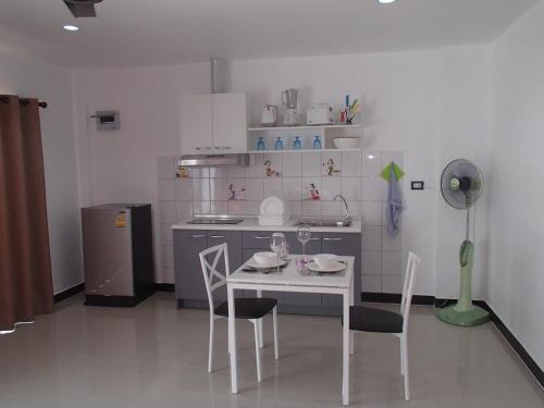a kitchen with a table and chairs in a room at Coconoi Residence in Nai Harn Beach
