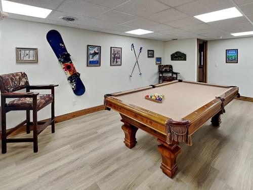 a room with a pool table and a snowboard on the wall at Buzzy Bee Lodge in McHenry