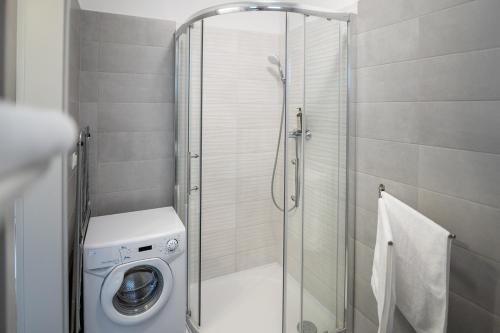 een douchecabine met een wasmachine in de badkamer bij Antracit Apartman - free parking in Pécs