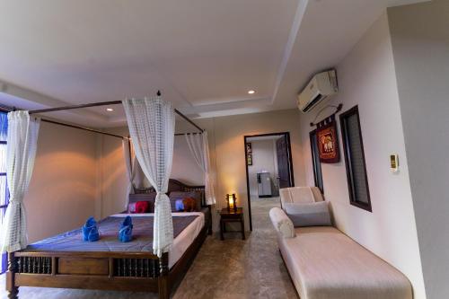 a bedroom with a bed and a couch and a chair at Khaoyai Nature Life & Tour Resort in Nong Nam Daeng