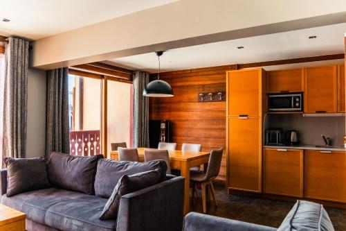 a living room with a couch and a table at Résidence Montana Caron by Village Montana in Val Thorens