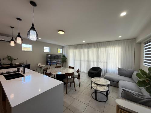 a kitchen and living room with a couch and a table at Pet Friendly &Home away From Home & Resort Facility in Rochedale