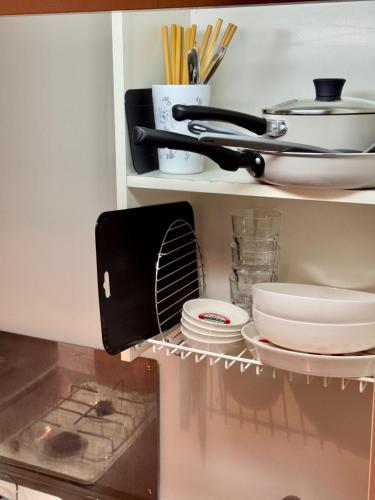 a shelf with plates and dishes in a kitchen at セレーナ南福岡 in Fukuoka