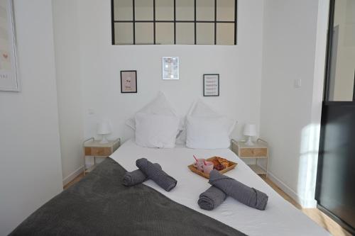 a bed with two pillows on top of it at La Campus Douillet in Saint-Étienne