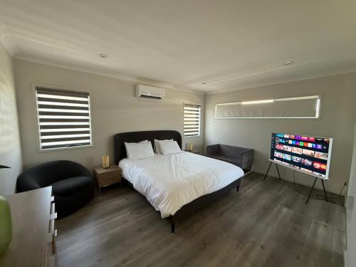 a bedroom with a bed and a flat screen tv at Pet Friendly &Home away From Home & Resort Facility in Rochedale