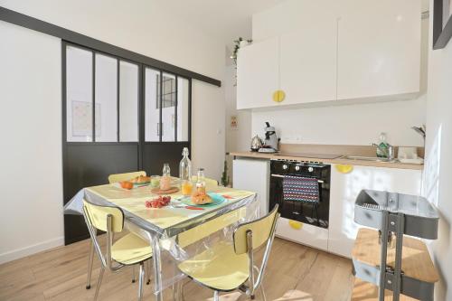 a kitchen with a table and chairs in a kitchen at La Campus Douillet in Saint-Étienne