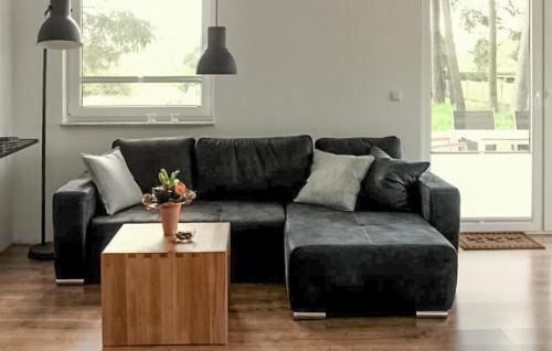 een woonkamer met een zwarte bank en een salontafel bij K104 Eg in Marienfelde