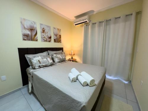 a bedroom with a bed with two towels on it at Espaçosa casa com WI-FI Perto do Aroporto - Conforto e Praticidade in Joinville