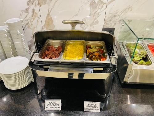 un buffet con vassoio di cibo su un tavolo di Hotel Diego de Almagro Pudahuel Aeropuerto a Santiago