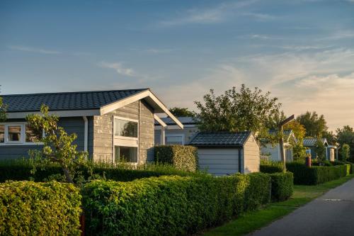 a house with bushes in front of a street at Siblu Camping in de Bongerd in Oostkapelle