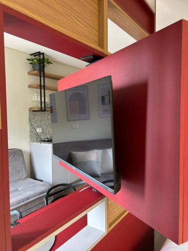 een rode muur met een tv in een kamer bij BetaSuites in Curitiba