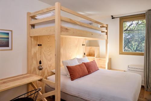 a bedroom with two bunk beds in a room at Kaze Océan, The Originals Relais in Cap-Ferret