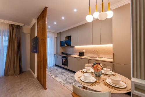 une cuisine avec une table avec des chaises et une salle à manger dans l'établissement Ivory Garden Studio by Blvd 51B7 - Premium Voluntari Stay, à Bucarest