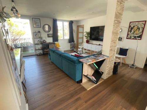 a living room with a blue couch and a television at Elegant apartment Saint-Raphaël in La Celle-sous-Gouzon