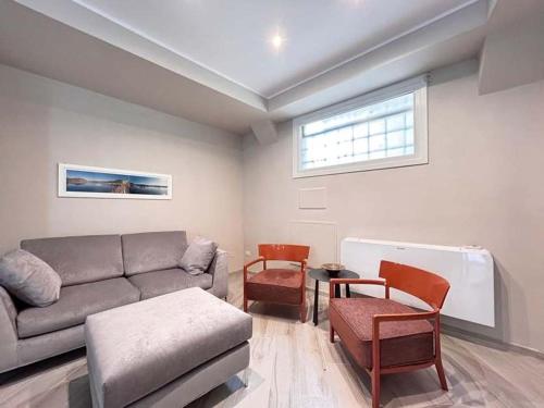 a living room with a couch and chairs and a window at Homeby, Modern Loft Pisa in Pisa