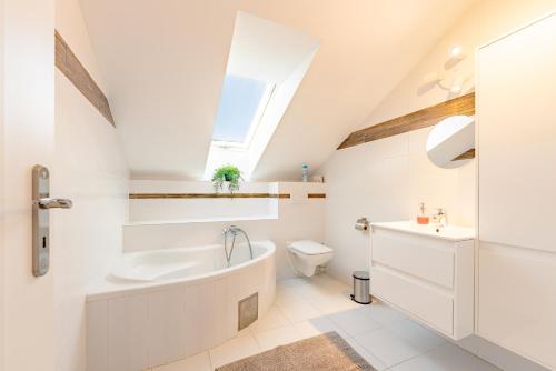 Nová LipnicaWellness apartmány Fürst的带浴缸、马桶和窗户的浴室