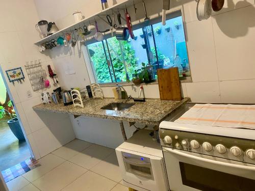a kitchen with a counter and a sink and a stove at Quintal do Bueno in Goiânia