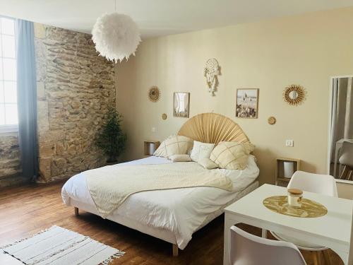 a bedroom with a bed and a stone wall at Les chambres d'Ursule in Tartas