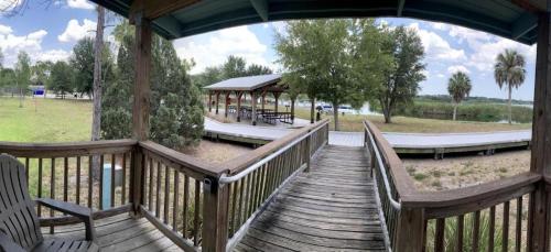 a wooden walkway with benches and a pavilion in a park at Lakefront Cabin Rental in Bradenton, Florida in Eastgate