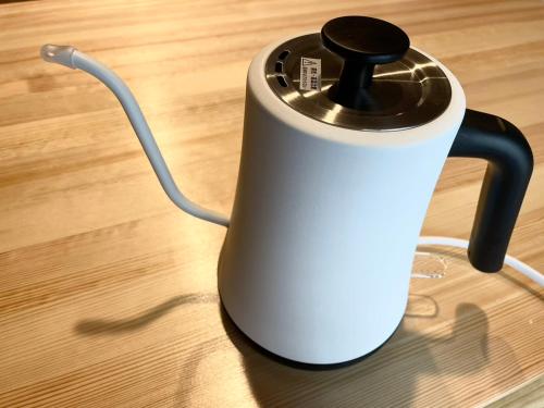a black and white kettle sitting on a wooden floor at Hotel Kototoi Juku HAKU in Tokyo