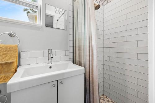 a white bathroom with a sink and a shower at Pool and Close to dtwn w2 Bikes in St Petersburg