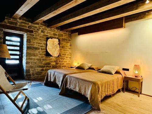 een slaapkamer met een bed en een bakstenen muur bij Equisoain in Monreal