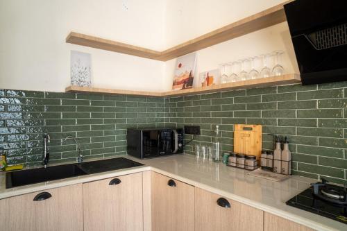 a kitchen with green tile on the wall at Ahrin House-entire villa with kitchen and parking in Dharmsala