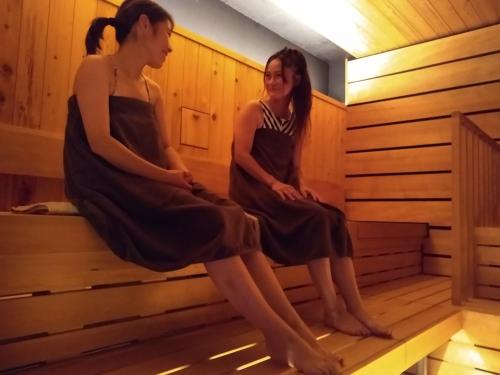 two women sitting in a sauna at Heidi Guest House in Yuzawa