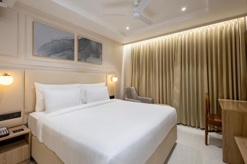 a bedroom with a large white bed in a room at Monday Premium Madhapur in Hyderabad