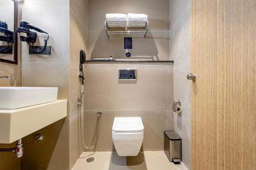 a small bathroom with a toilet and a sink at Monday Premium Madhapur in Hyderabad