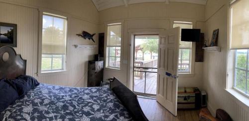 a bedroom with a bed and a door and windows at Lakefront Cabin Rental in Bradenton, Florida in Eastgate