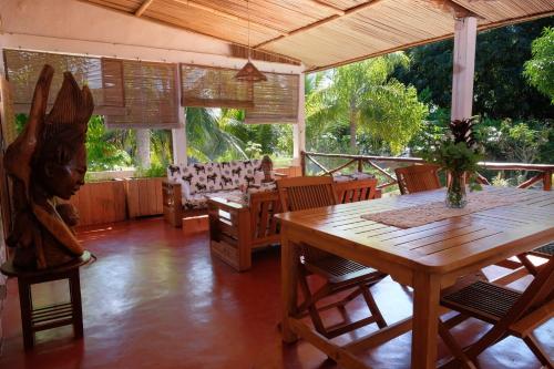 a dining room with a wooden table and chairs at Villa Ilo Komba in Ampangorinana