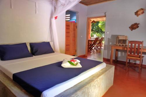 a bedroom with a bed and a table and chairs at Villa Ilo Komba in Ampangorinana