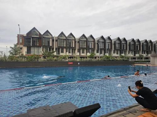a group of people swimming in a swimming pool at Apartemen OSAKA Riverview PIK2 Studio By GPI in Rawalumpang