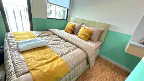 a bedroom with a large bed with yellow pillows at Apartemen OSAKA Riverview PIK2 Studio By GPI in Rawalumpang