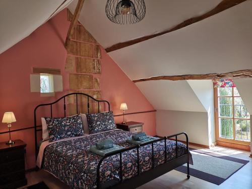 ein Schlafzimmer mit einem Bett auf einem Dachboden in der Unterkunft L'Hirondelle in Le Petit-Pressigny