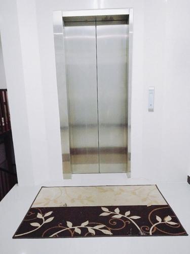 a glass shower stall in a room with a rug at Boomerang Inn in Patong Beach